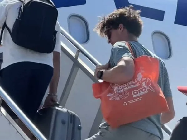 Extranjero abordando el avión con bolsa del Ara.
