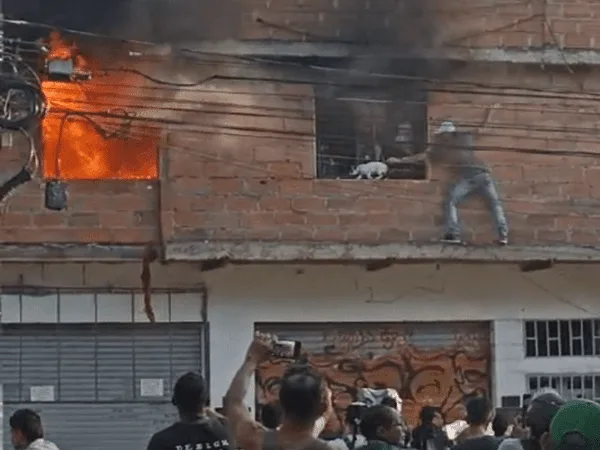 Los vecinos intentaban sofocar de las llamas del voraz incendio mientras los bomberos llegaban al sitio.
