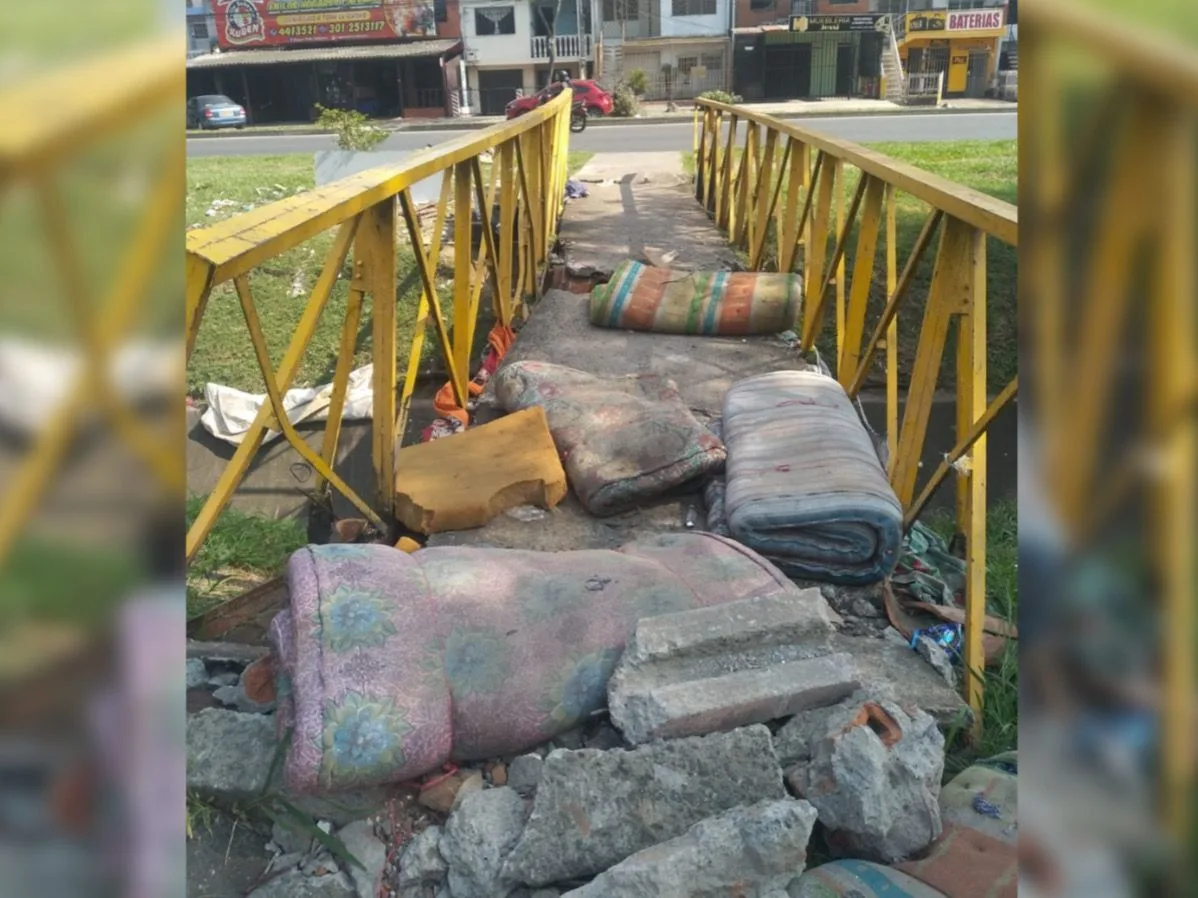 Con colchones viejos, huecos y escombros: puente peatonal de la Autopista entre El Rodeo y Santa Fe en Cali