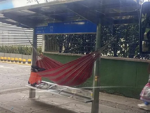 Hombre colgó hamaca en el MIO para dormir.