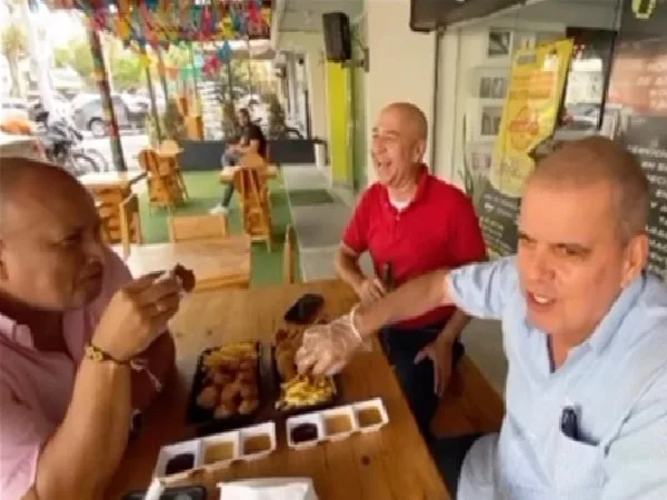 Personas comiendo en restaurante premia a todo aquel que sea calvo.