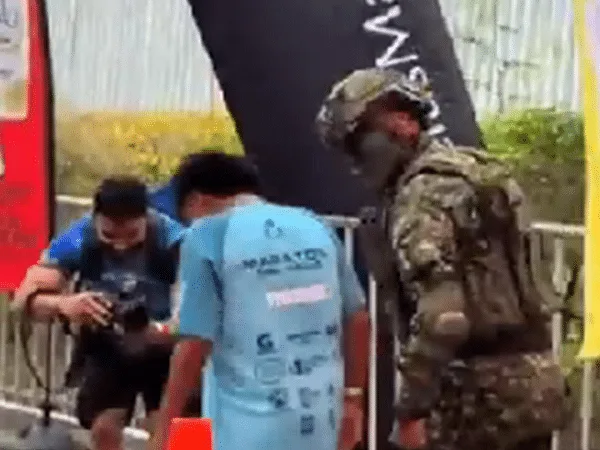 Soldado anima a niño maratonista a cruzar la meta,