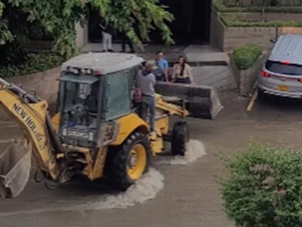 Retroexcavadora ayudó a cruzar a dos mujeres un arroyo.